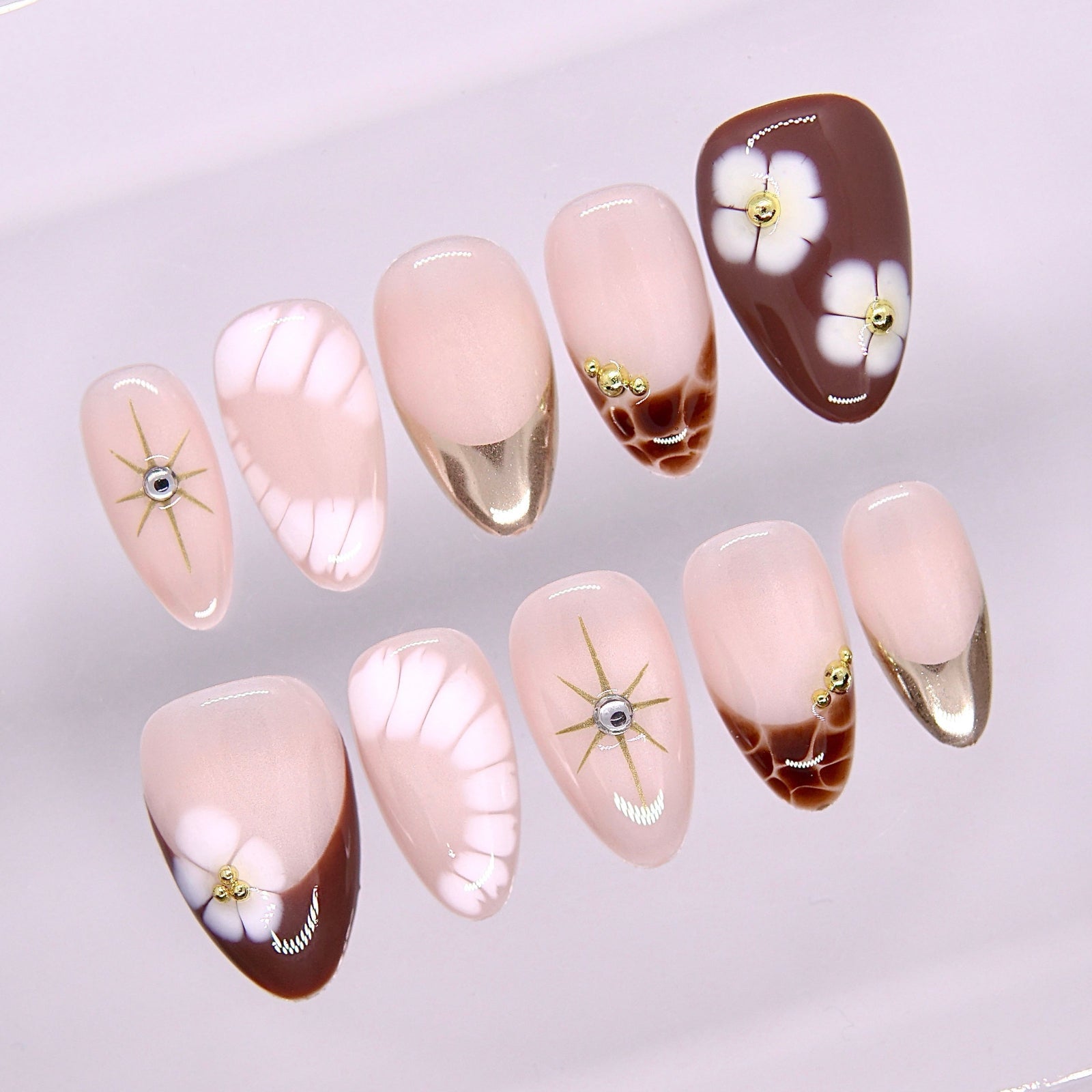 Close-up of Begin at Heart press-on nails showing hand-painted floral elements and soft blush base
