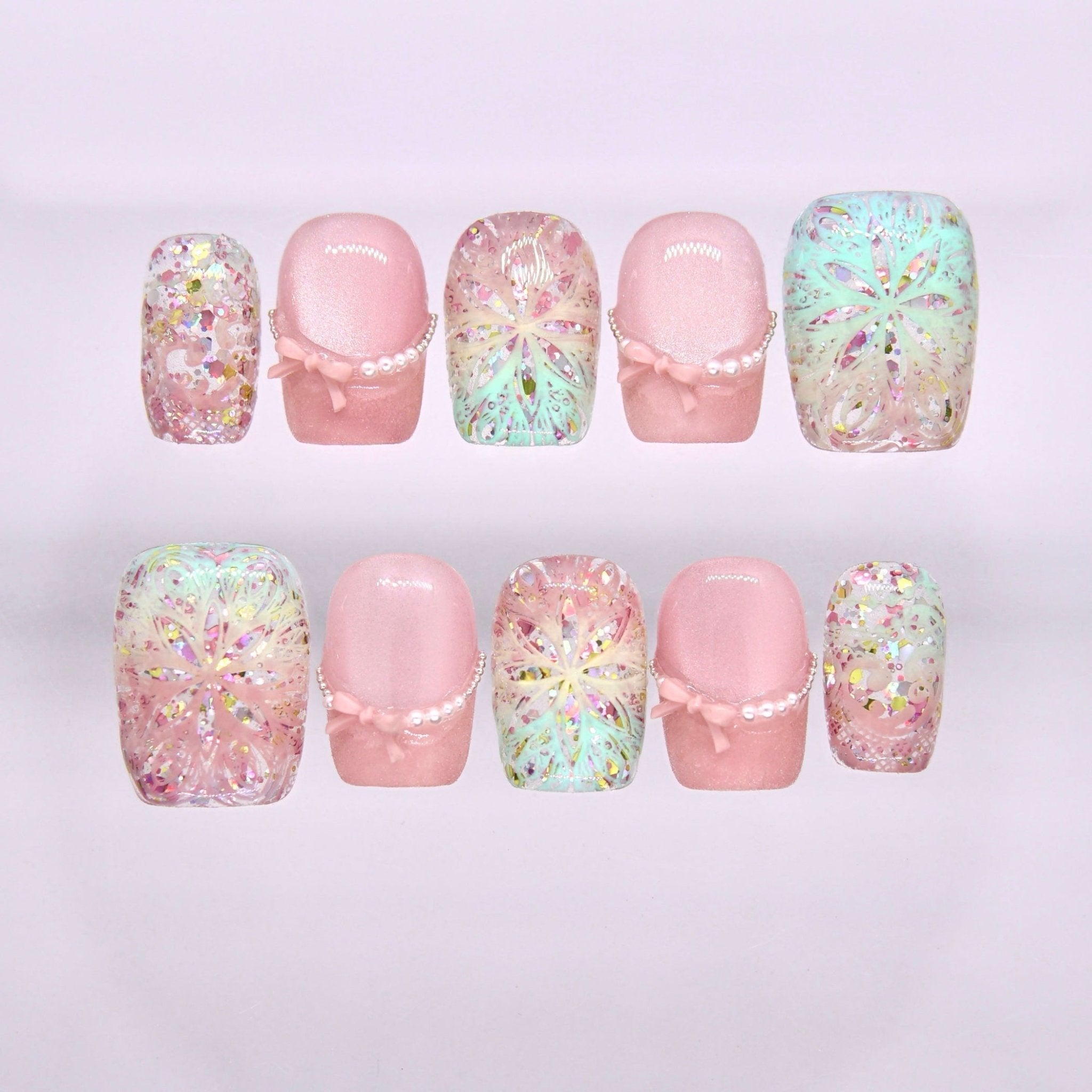 Begin Infinite press-on nails set with soft pink base, iridescent pastel kaleidoscope pattern, and glitter accents
