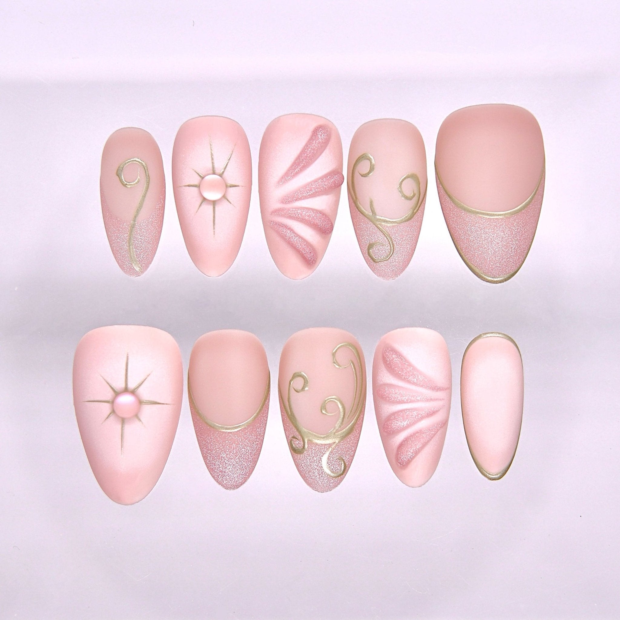 Begin with Trust press-on nails set featuring blush pink tones with celestial gold linework and soft shimmer finish