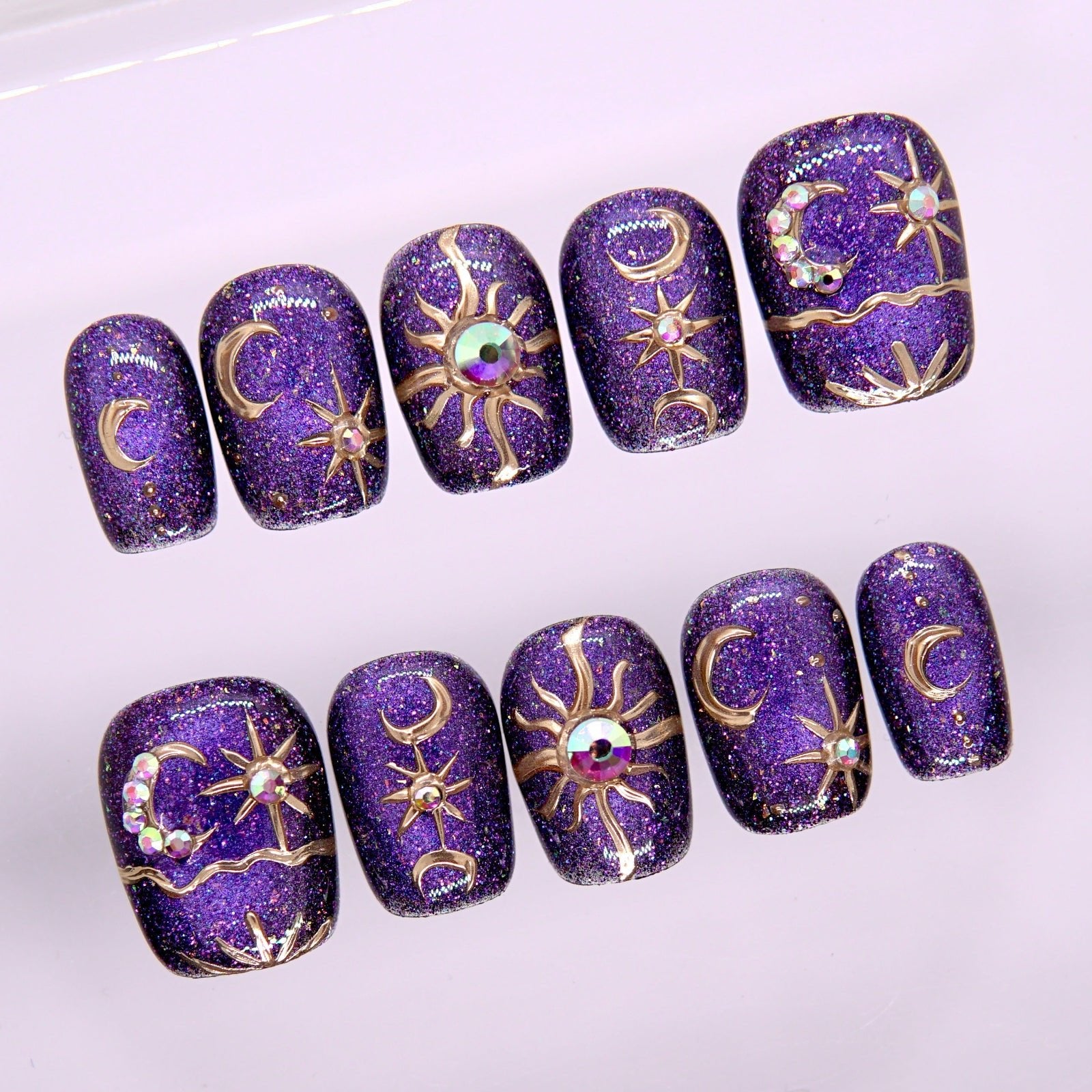 Close-up of Begin with Wonder press-on nails showing gold celestial accents and star-inspired design