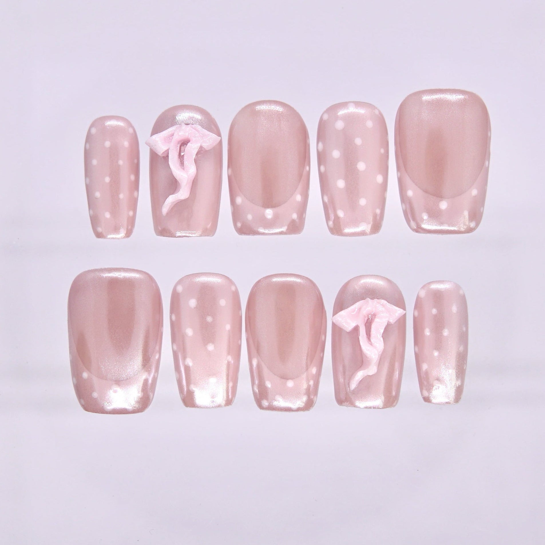 Pig zodiac press-on nails in sheer blush pink shimmer with white polka dots and 3D bow accents, symbolizing Bliss and gentle self love.