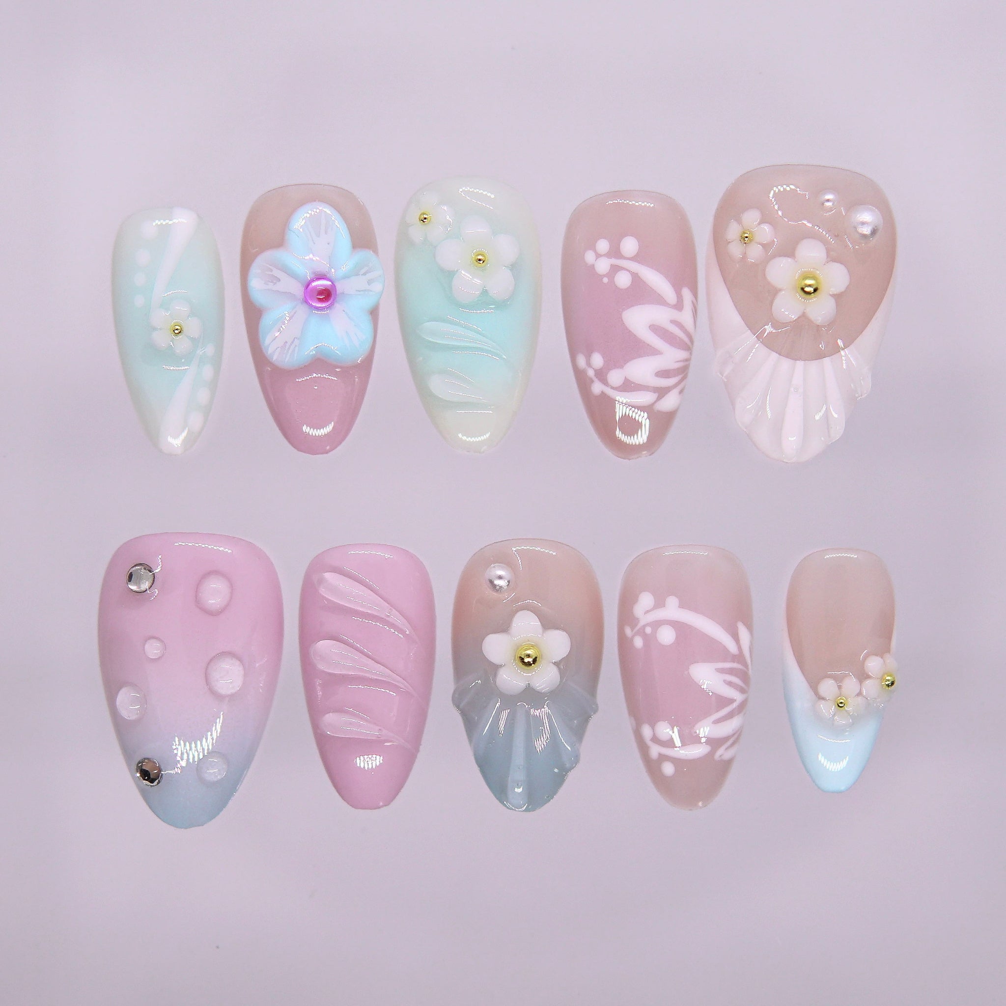 Candy Garden press-on nails with mint, blush pink, and baby blue pastels, pearly flowers, and shell accents – playful Wood · Bloom design by Nailsium.