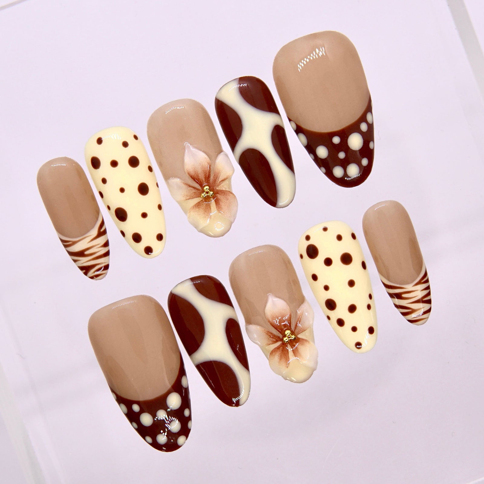 Close-up of Caramel Bloom nails showing polka-dot pattern and soft caramel tones.