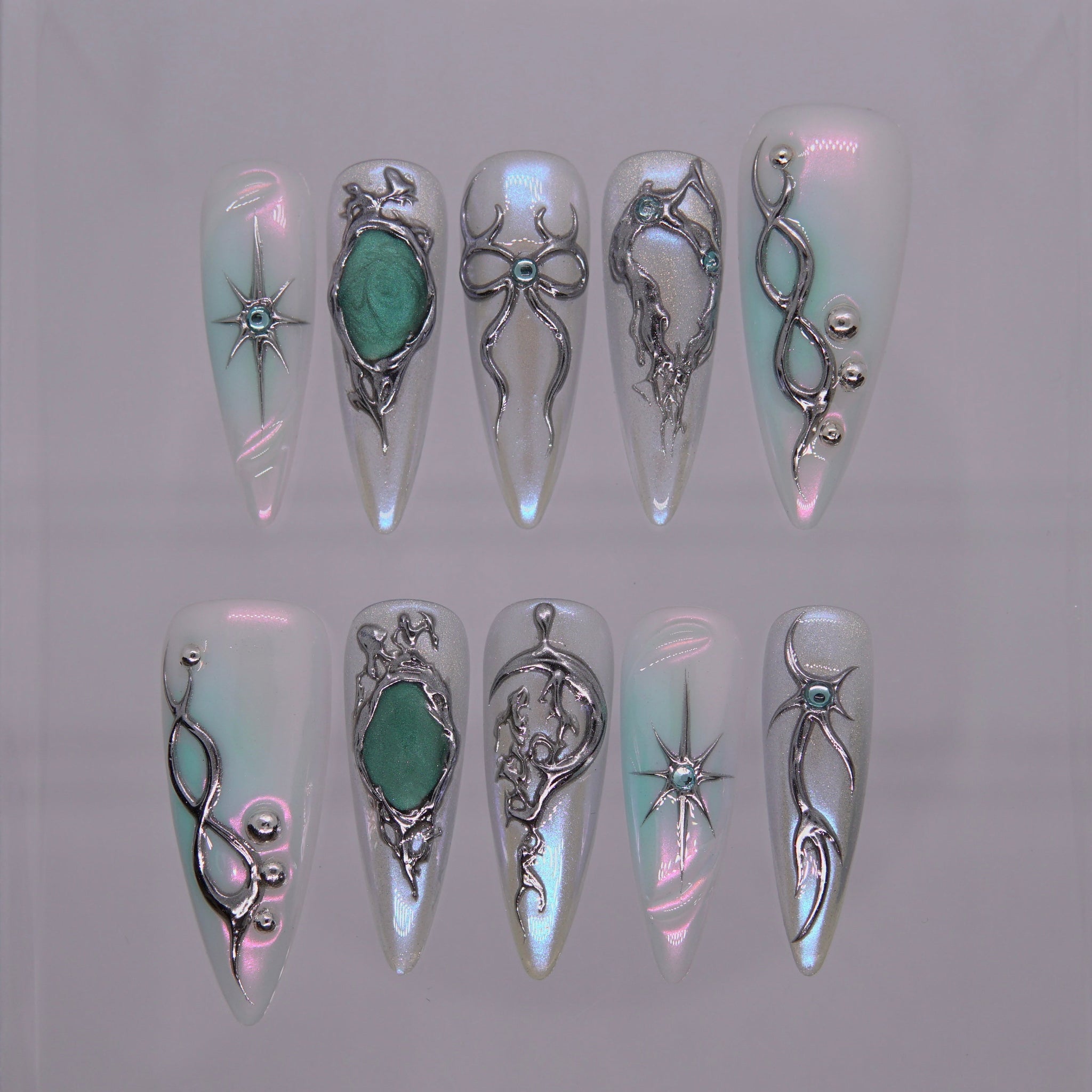 Ether Conduit press-on nails — chrome and opal gradient with emerald accents, long almond shape.