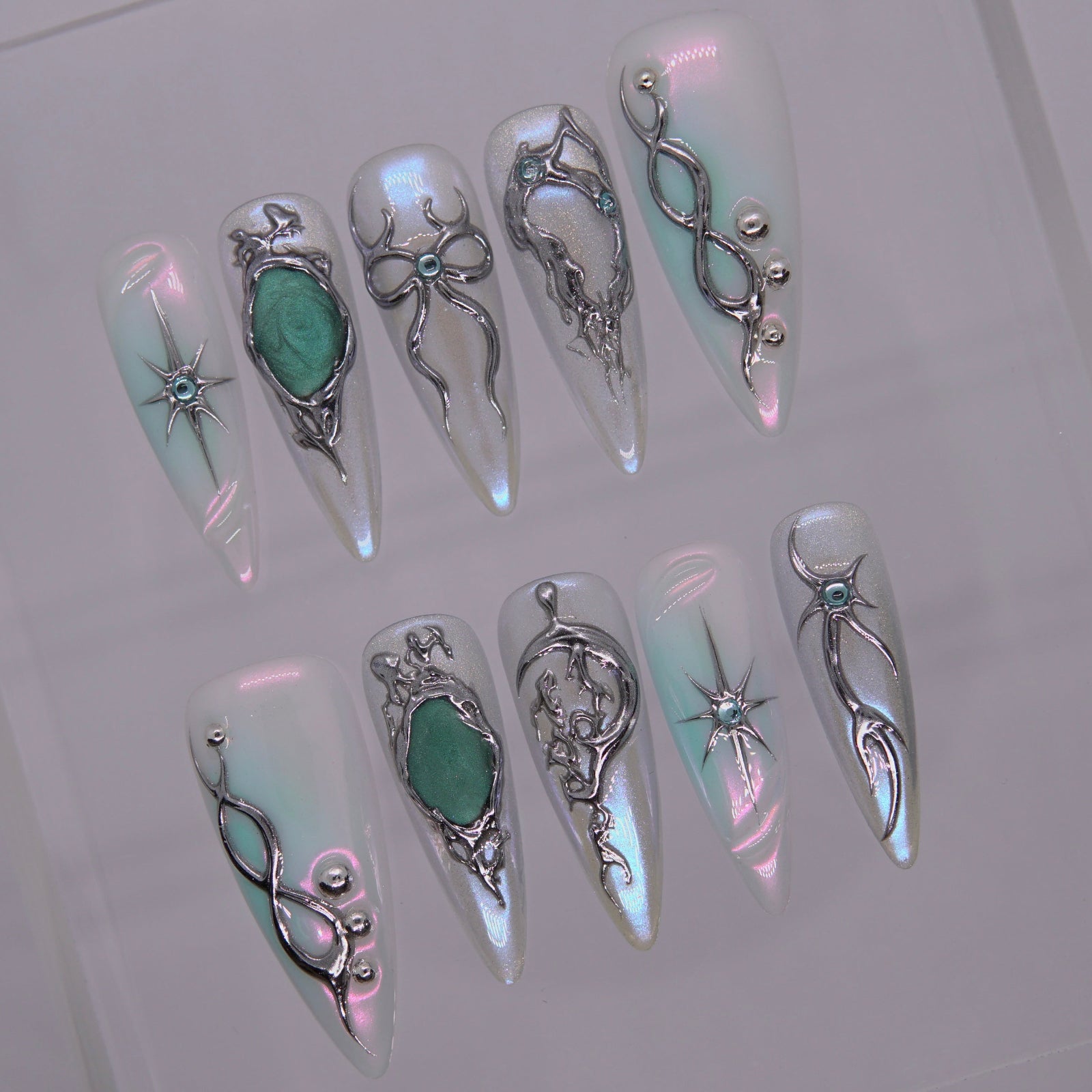 Close-up of metallic conduit lines and green gemstone center.