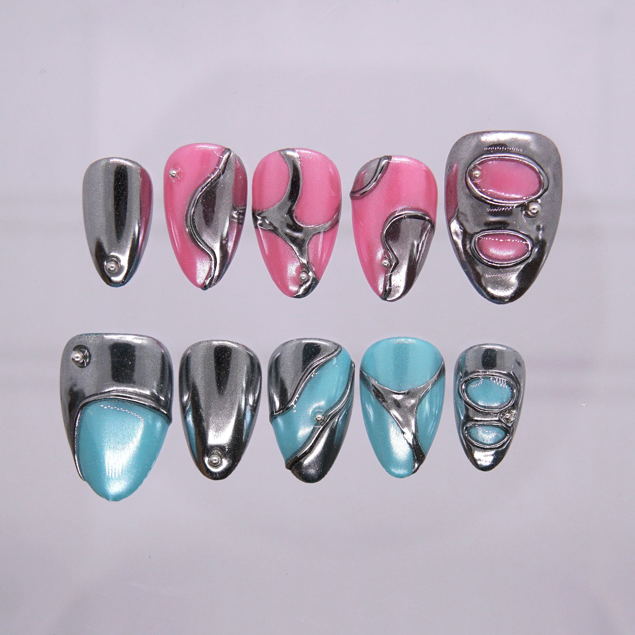 Product main image alt text: Mirror Error chrome pink and blue mixed length press-on nails with abstract metal details.