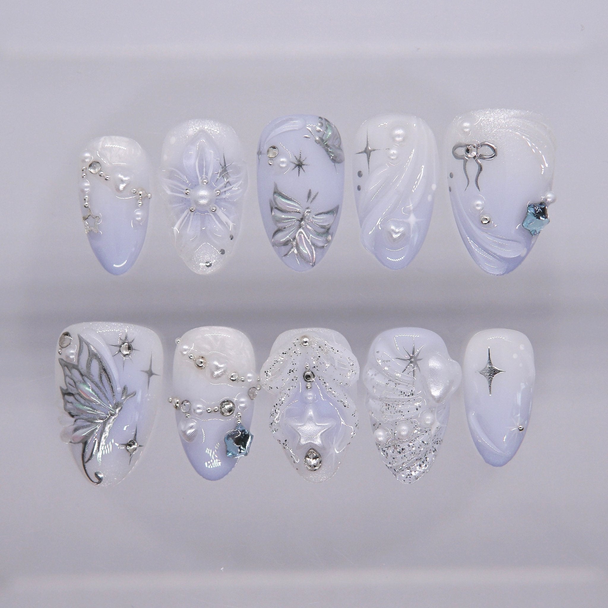 Moonlit Wings press-on nails with icy blue and pearly white gradient, silver butterflies, and star accents – dreamy Water · Flow design by Art By Cloe.