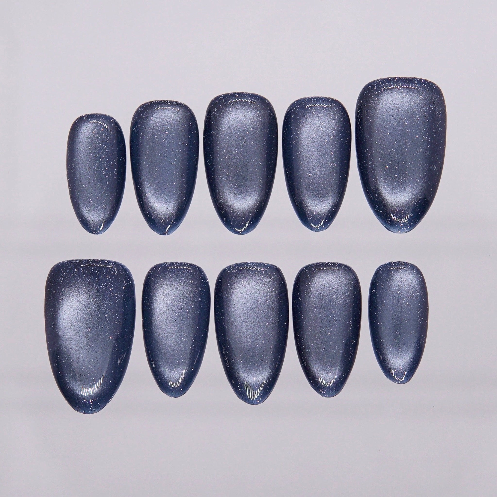 Deep steel-blue cat eye press-on nails with metallic shimmer from Nailsium