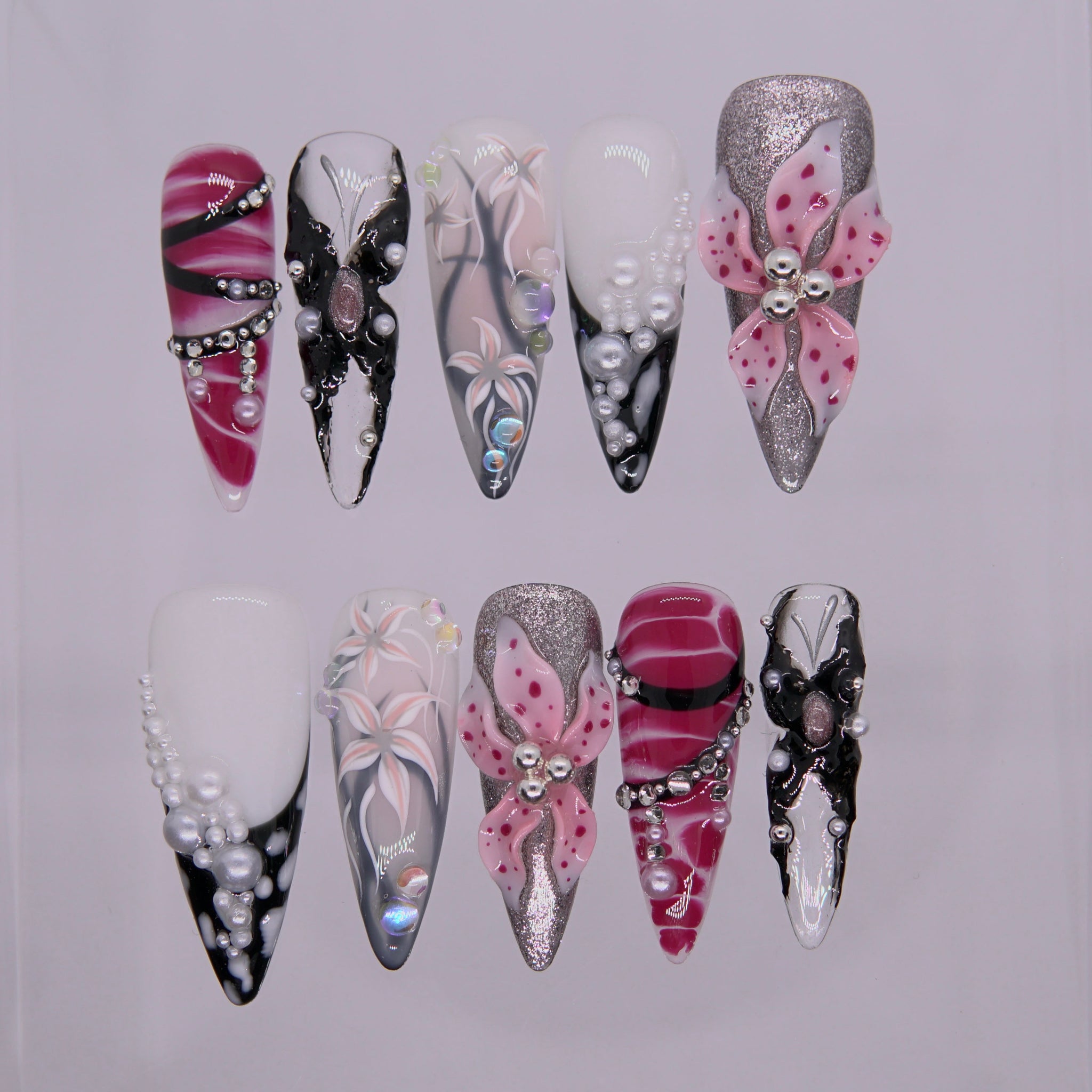 Obsidian Bloom press on nails — black gloss with white 3D blossoms and pearl detailing, inspired by emotional alchemy.