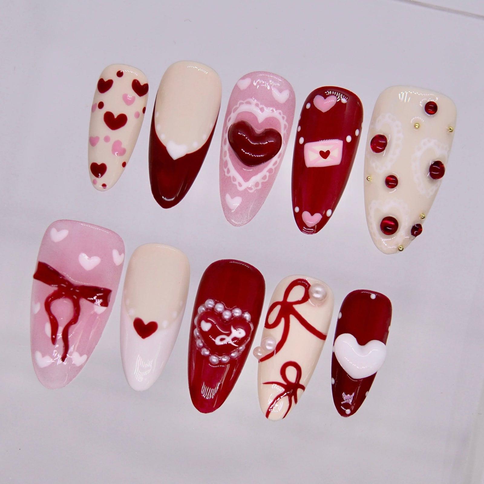 Close up of Rooster Radiance press on nails with heart details and glossy finish
