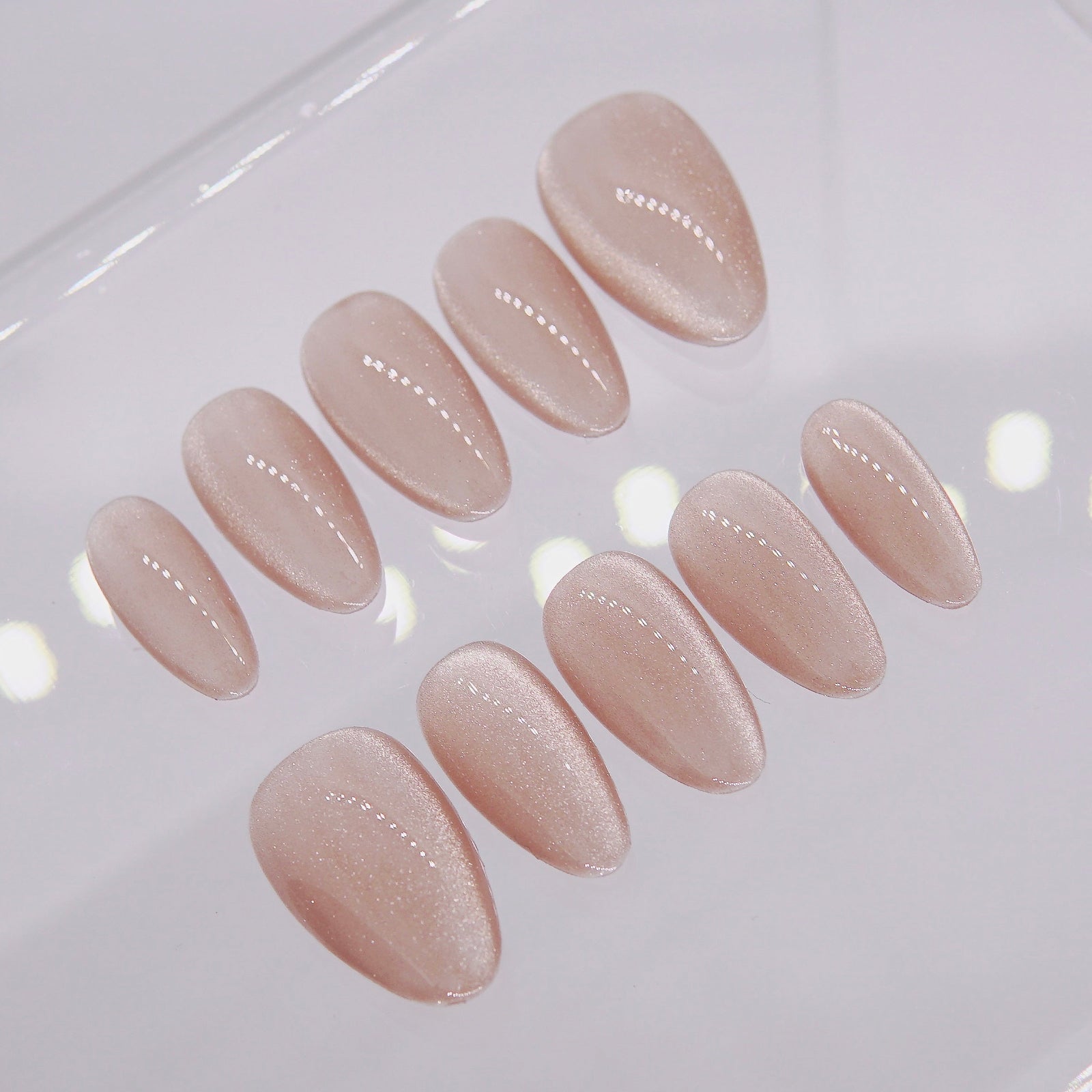 Detail view showing sheer shimmer texture of Soft Base nude pink press-on nails.